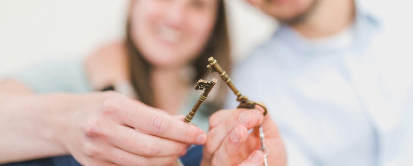 Happy expat couple holding villa keys in front of their new Dubai home