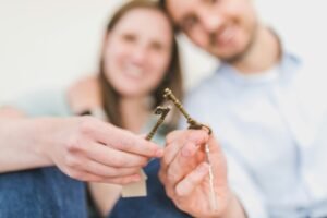 Happy expat couple holding villa keys in front of their new Dubai home