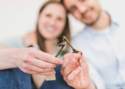 Happy expat couple holding villa keys in front of their new Dubai home